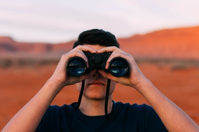 man takes a closer look at scenery with binoculars 