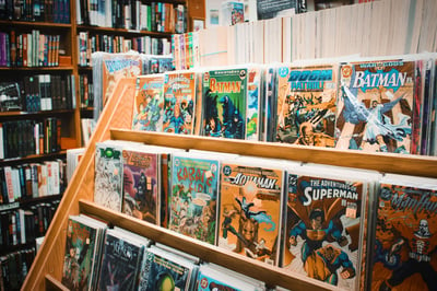 Superhero comics lined up on a shelf in a store