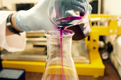 scientist pouring liquid for an experiment