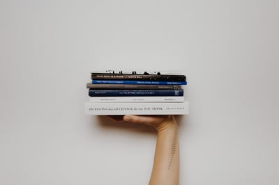 Stack of books being held by a hand